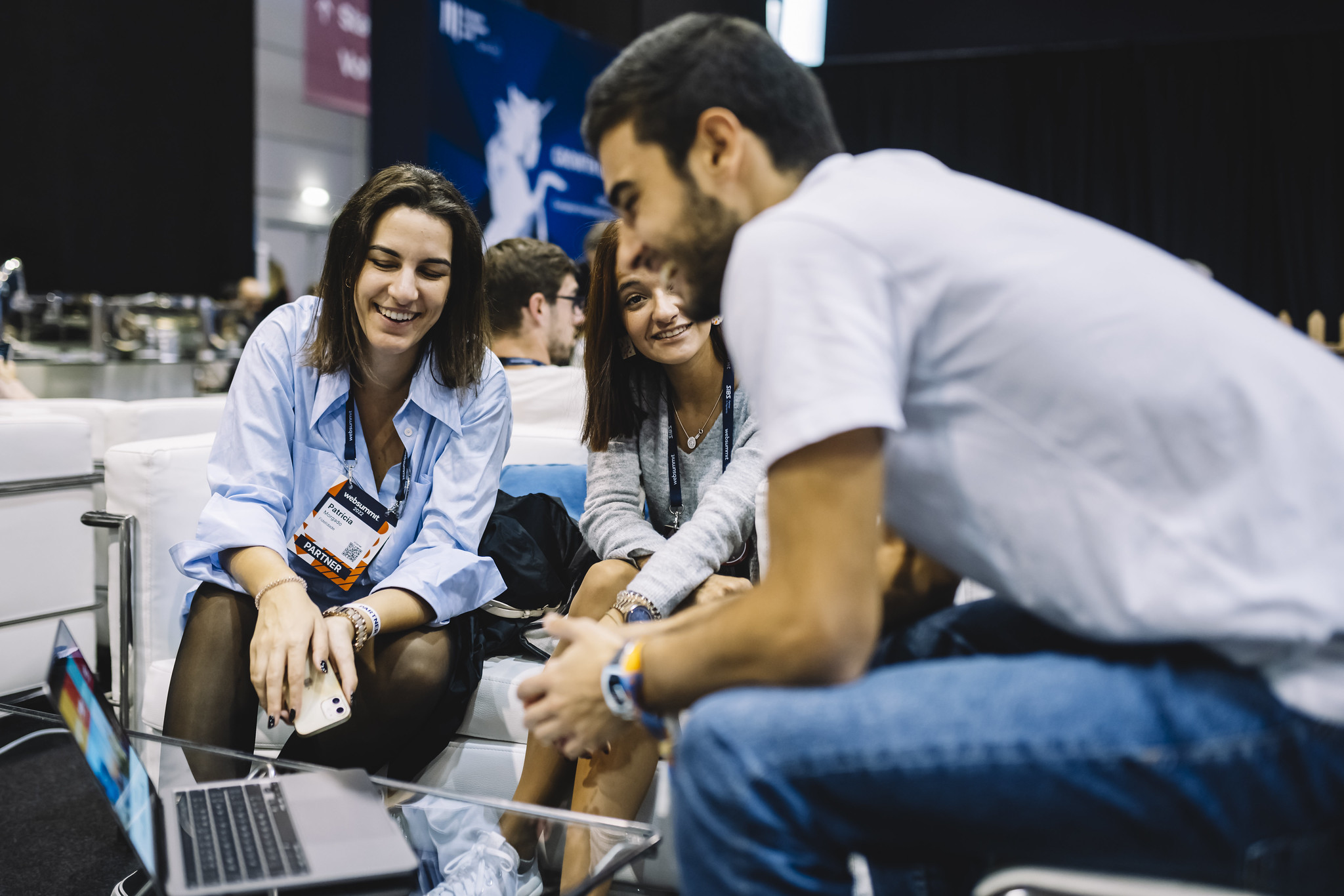 three attendees smiling and chatting around a laptop