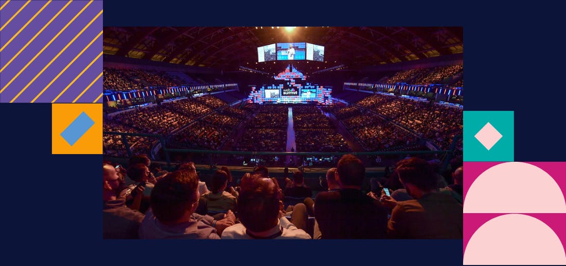 The camera is behind Web Summit attendees looking down onto centre stage.