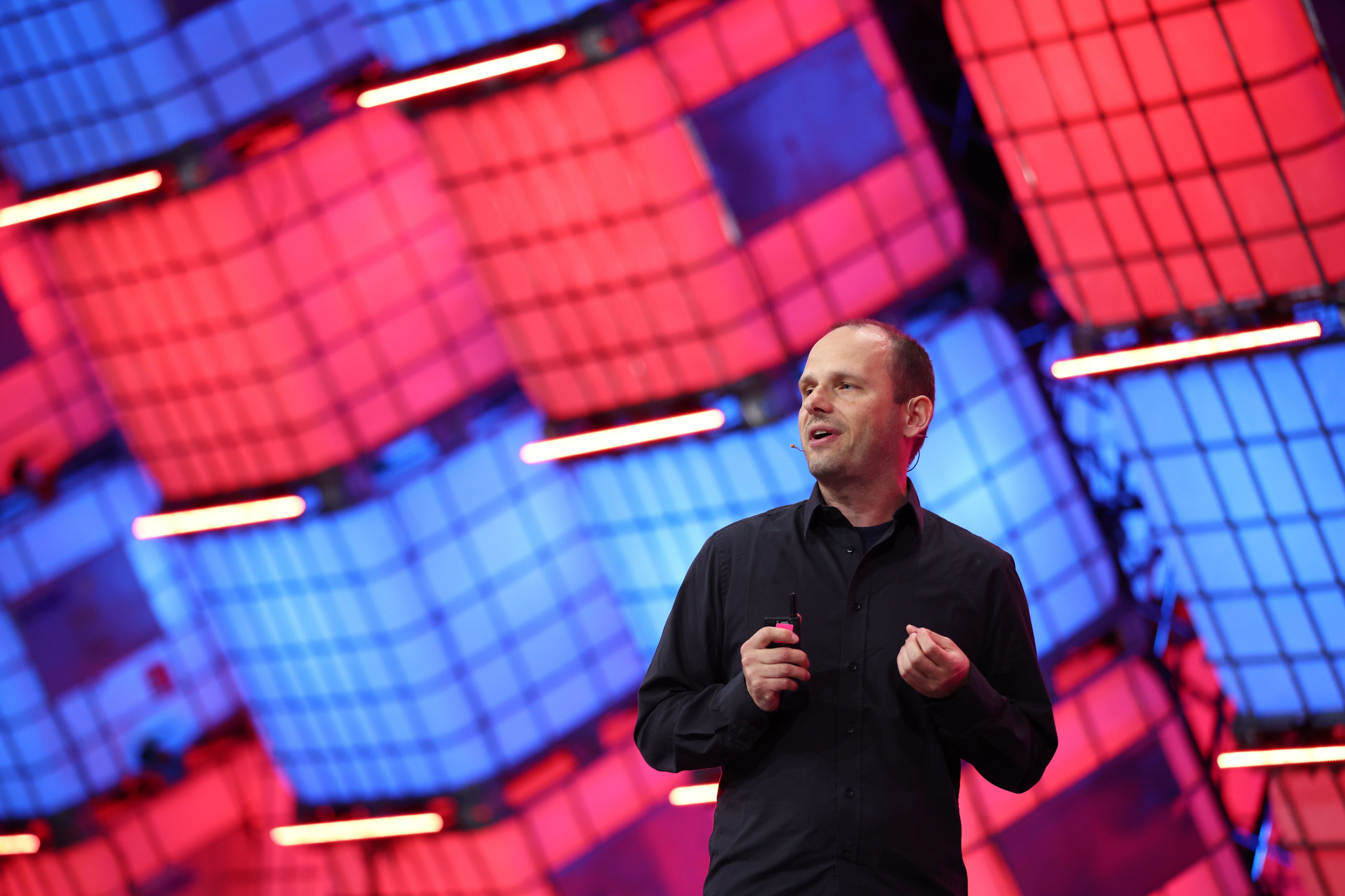 A photograph of a person (Thomas Dohmke, CEO of GitHub) speaking on Centre Stage at Web Summit. The photo is zoomed out, and the person is using their hands to speak. They appear to be speaking to an audience.