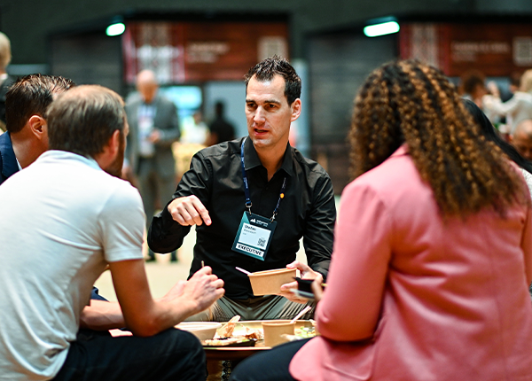 A photograph of four Web Summit attendees sitting in a circle and conversing.