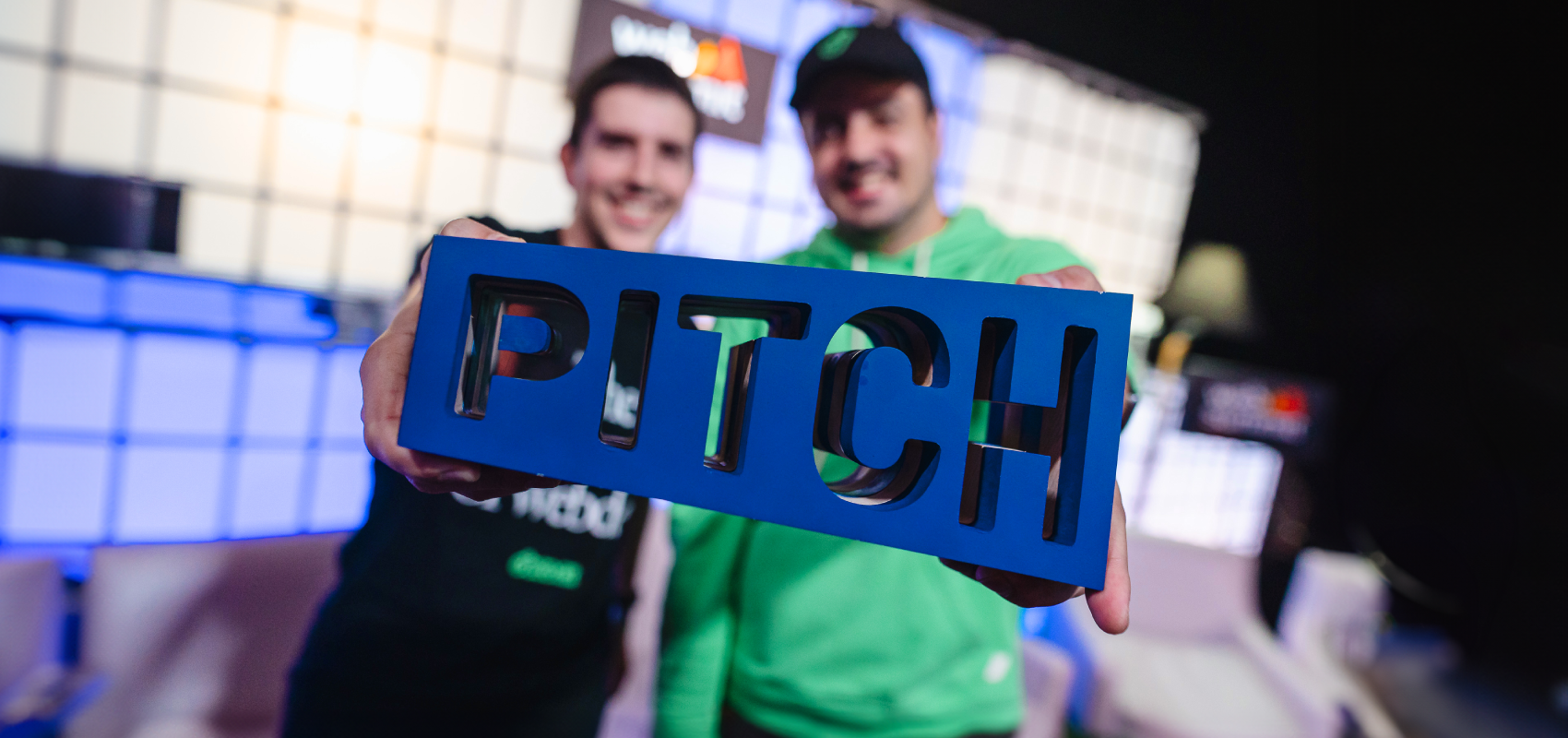 Pitch advice image. Two people hold a PITCH trophy to the camera, standing on stage at Web Summit.