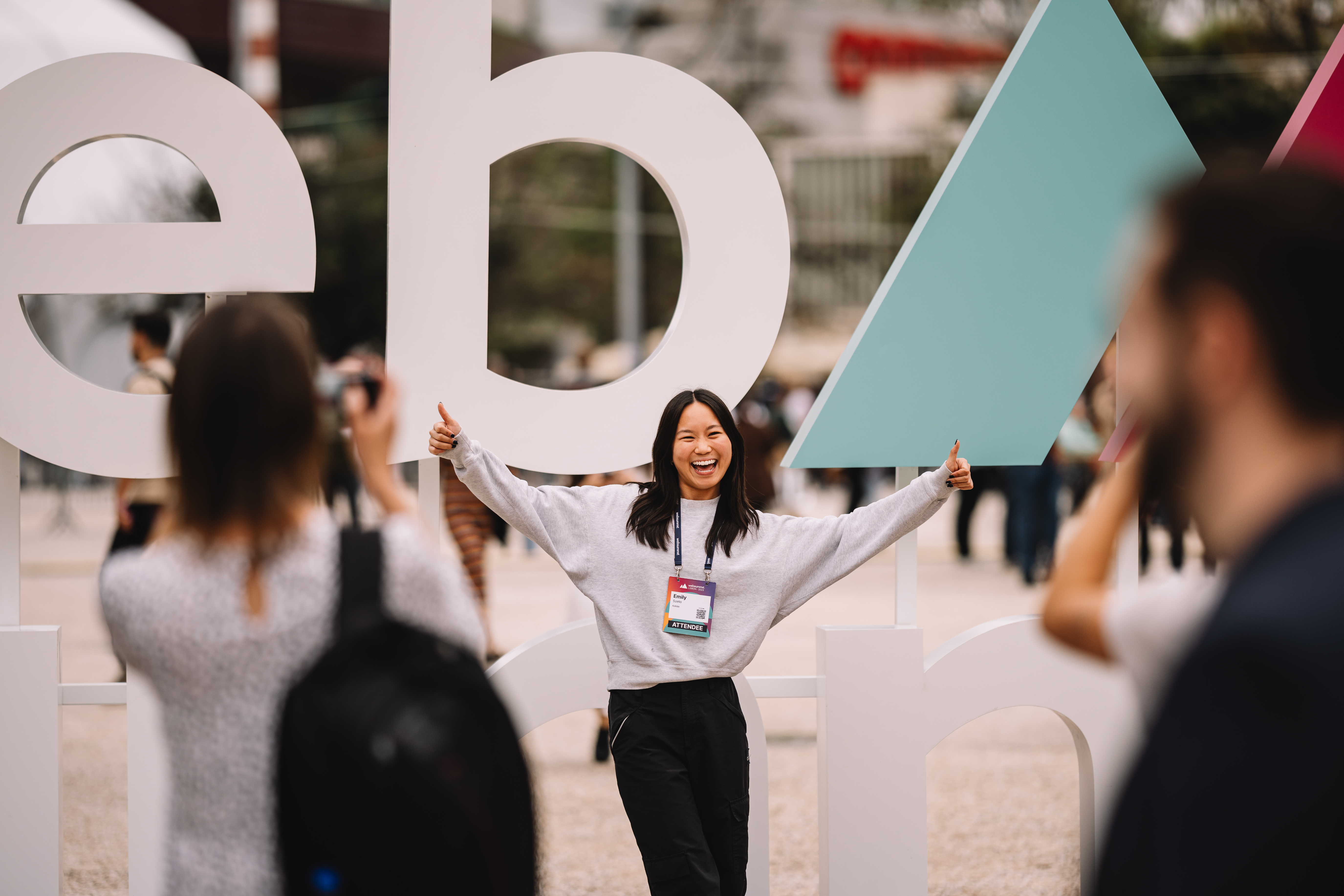 Web Summit attendee smiling in front of branding activation at MEO Arena