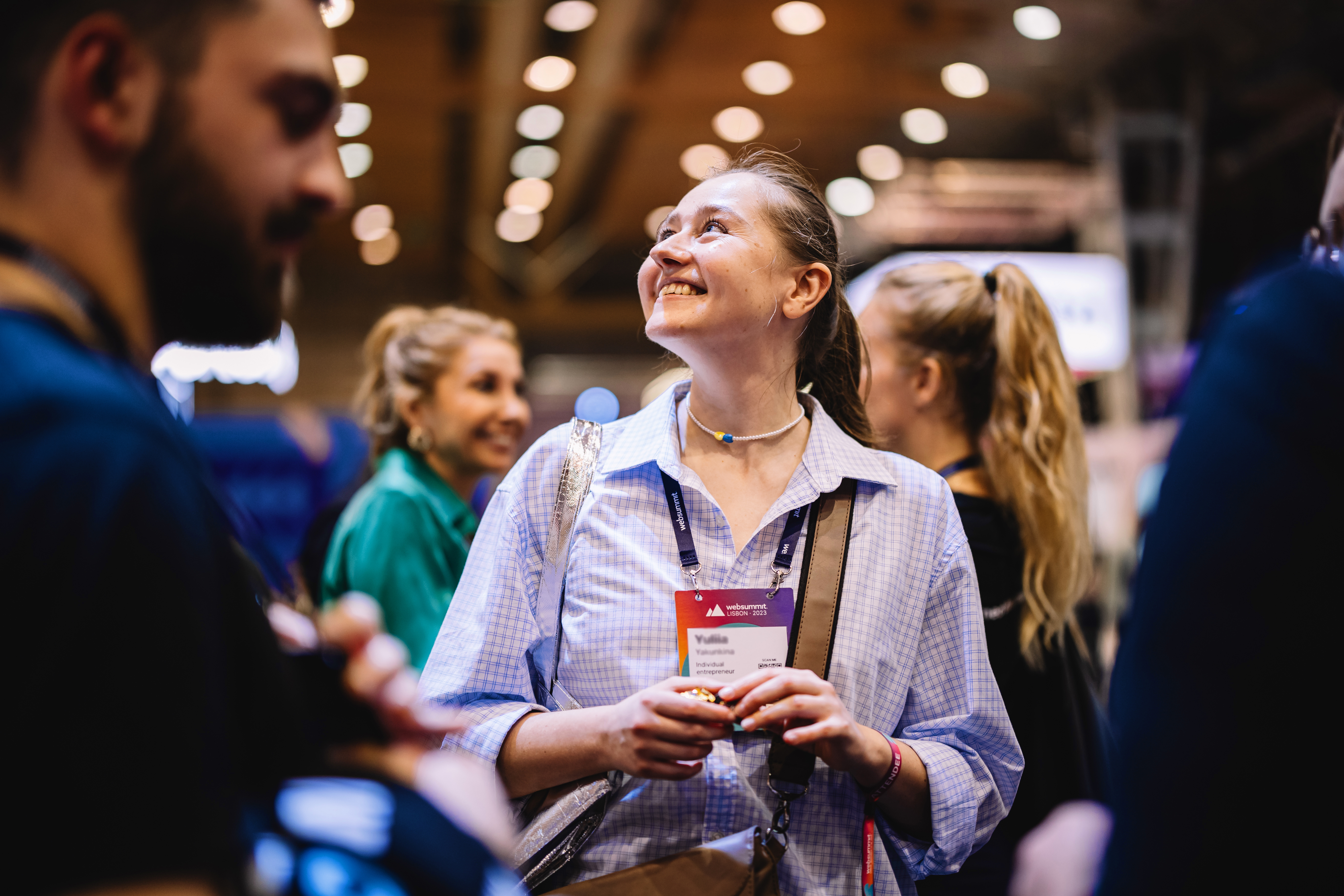 Young Web Summit attendee holding lanyard and smiling